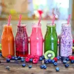 Five colorful smoothie bottles featuring fruit, berry, and green smoothies—perfect for easy summer breakfast ideas.