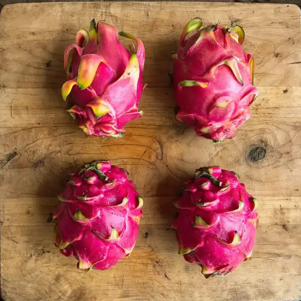 Close-up of a whole dragon fruit on a wooden surface
