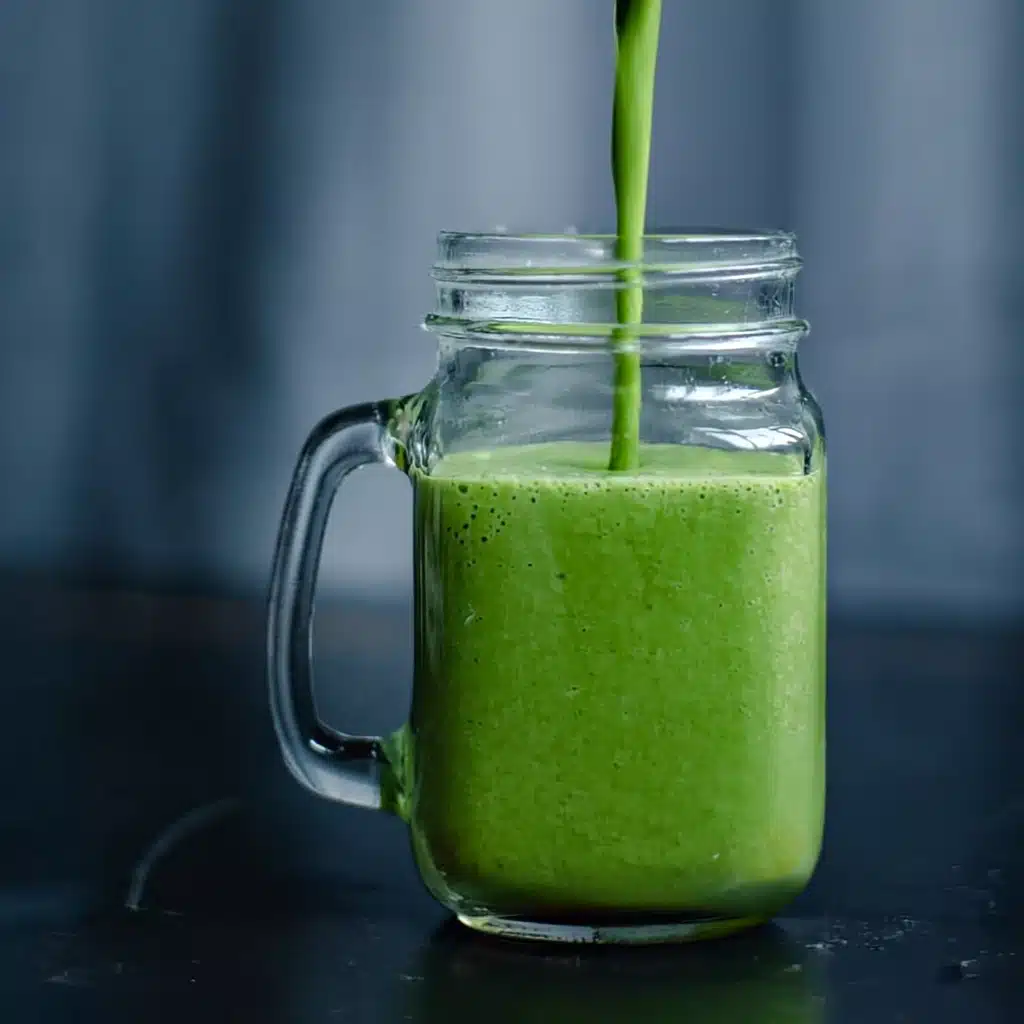 A mason jar filled with a thick green energy smoothie made with leafy greens—perfect for healthy breakfast or post-workout fuel.