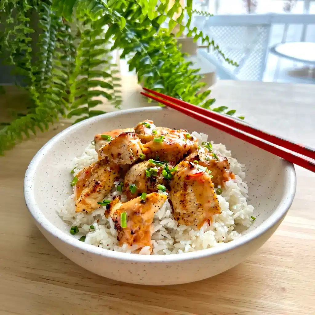 Grilled Bang Bang Chicken over fluffy Basmati rice, topped with sweet chili sauce and fresh herbs.