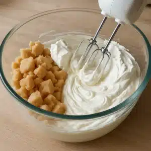 Marzipan and cream cheese being mixed for tart cheesecake filling