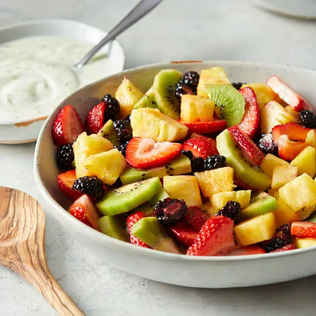 Fresh summer fruit salad with pineapple, kiwi, strawberries, and blackberries in a white bowl