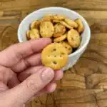 Hand holding a single Garlic Bread Ritz Bit with parsley seasoning