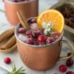 Cranberry Moscow Mule mocktail garnished with sugared cranberries and citrus slice.
