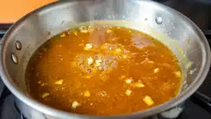 Huli Huli sauce simmering in a saucepan with ginger and garlic