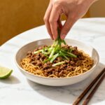 Serving Mongolian ground beef noodles in bowl