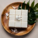 Haupia recipe served on a tropical wood platter with coconut garnish