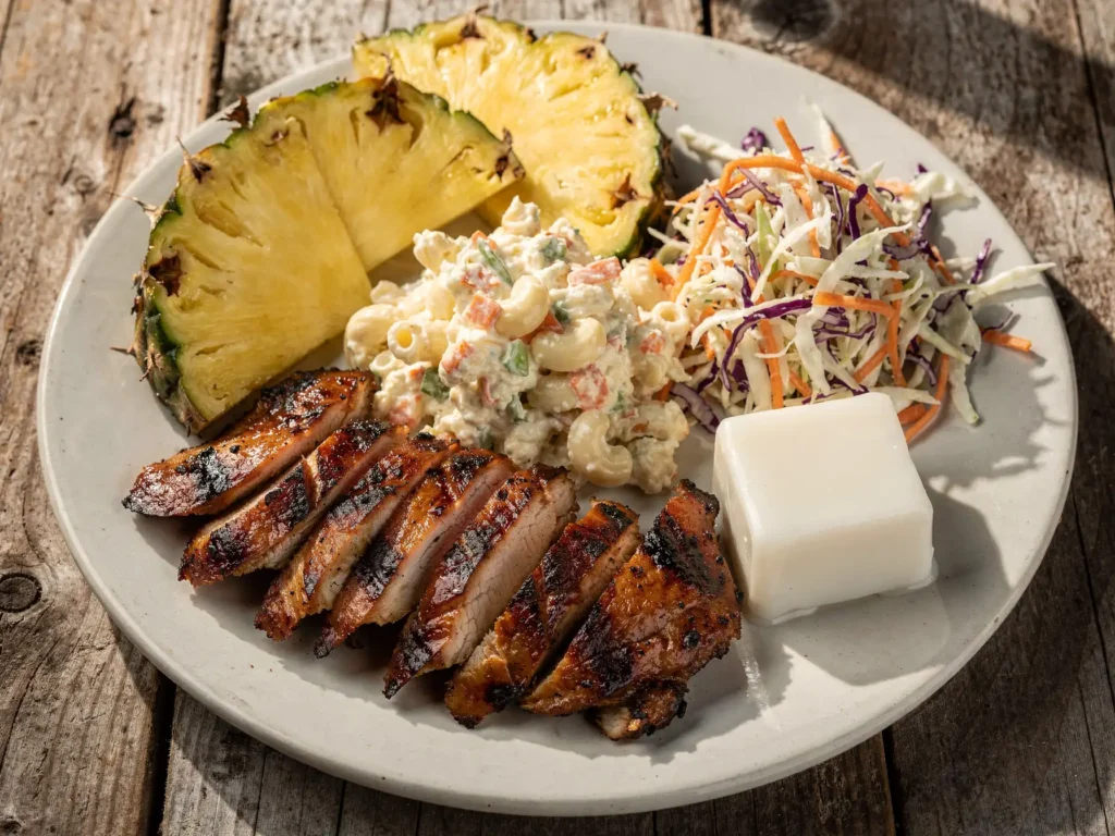 Hawaiian luau plate with savory dishes and haupia cube