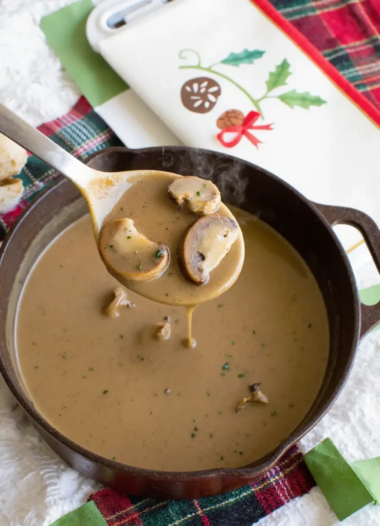 ladle lifting mushroom gravy from saucepan