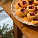 Thumbprint cookies with raspberry jam on a plate during the holidays